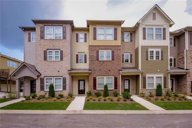 a front view of a brick house with yard in front of it