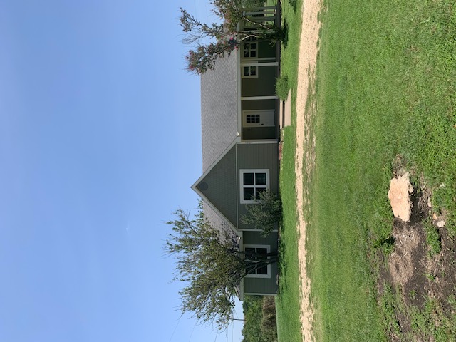 1501 North Burleson Street Kyle, TX 78640 - Photo 2 of 33 a front view of a house with a yard and trees