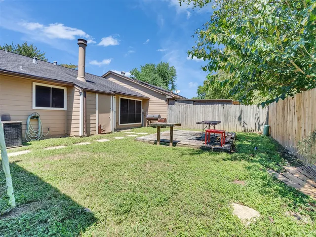 a backyard of a house with table and chairs