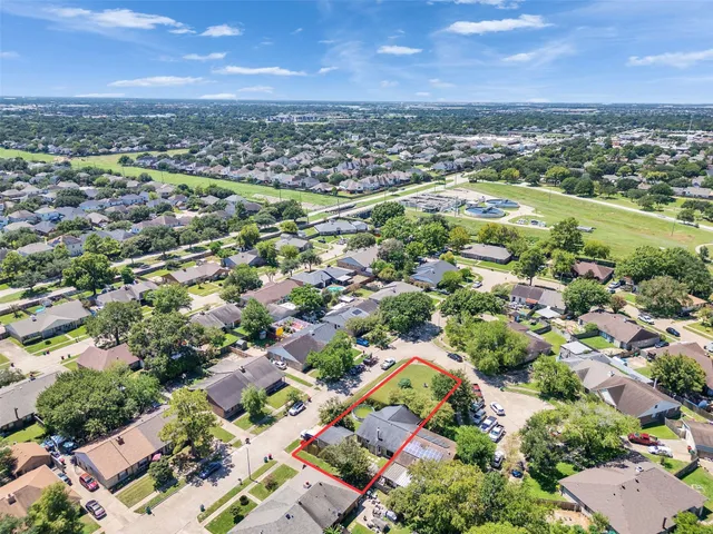 an aerial view of residential houses with outdoor space and trees