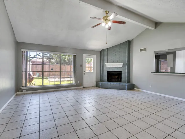 a view of an empty room with a fireplace and a window
