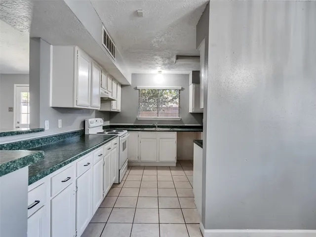 a large white kitchen with a sink and cabinets