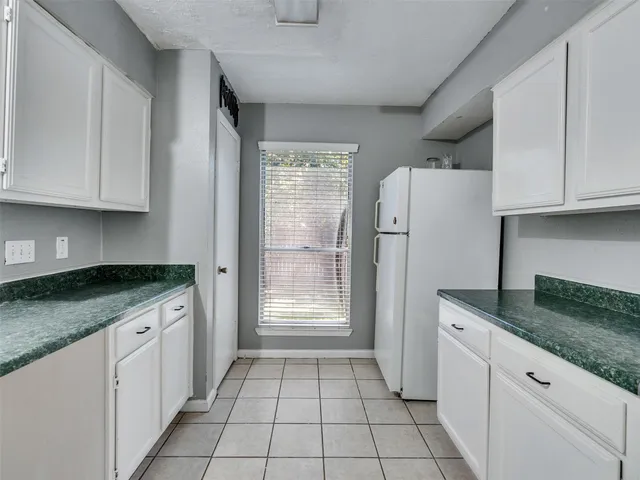 a kitchen with granite countertop a sink stove and refrigerator