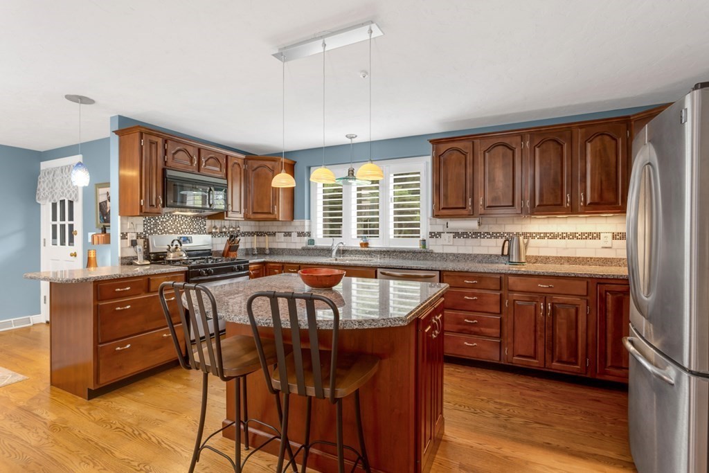 8 Mill River Drive Mendon, MA 01756 - Photo 13 of 42 a kitchen with stainless steel appliances granite countertop wooden cabinets a center island and a window
