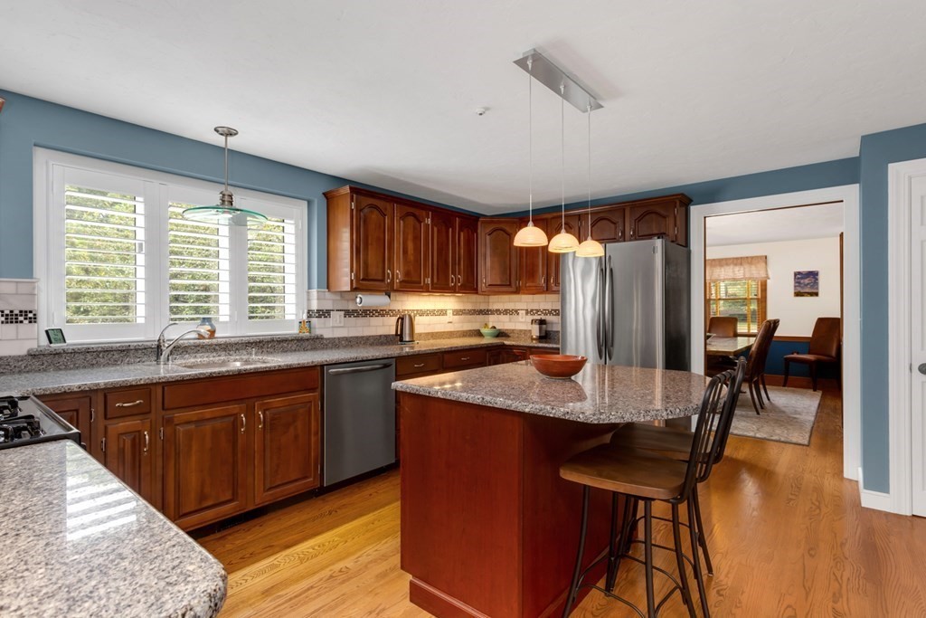 8 Mill River Drive Mendon, MA 01756 - Photo 16 of 42 a kitchen with stainless steel appliances granite countertop wooden cabinets a dining table and chairs