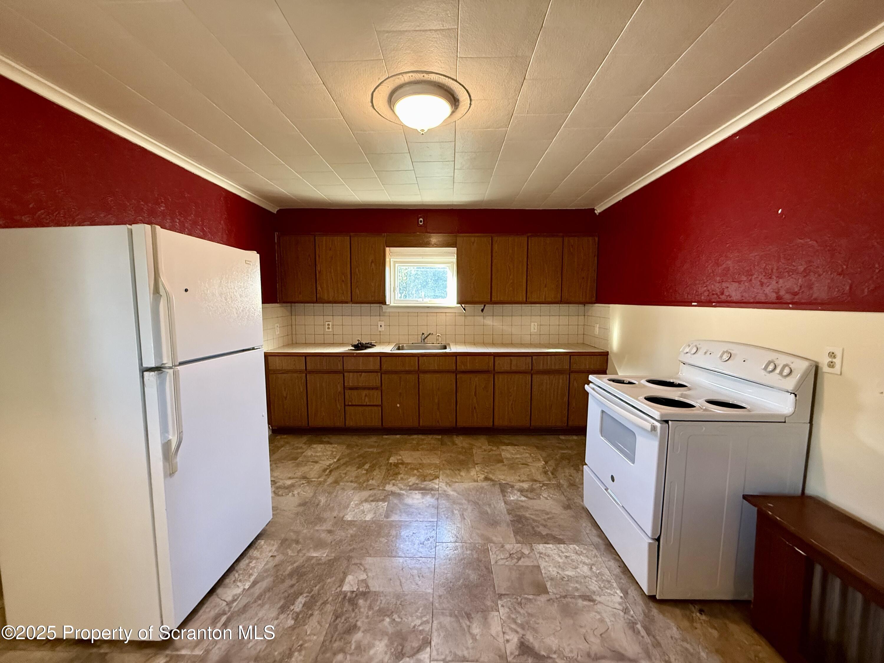 1315 Farr Street, Unit 2 Scranton, PA 18504 - Photo 6 of 14 a kitchen with granite countertop a refrigerator a stove a sink and a microwave