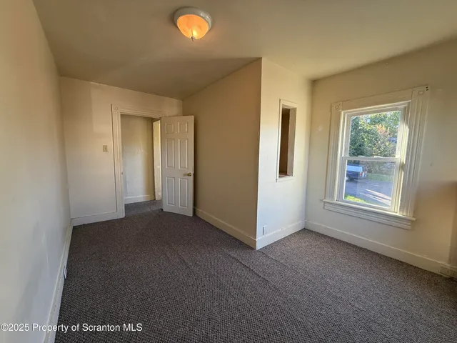 a view of a livingroom with an empty space and a window