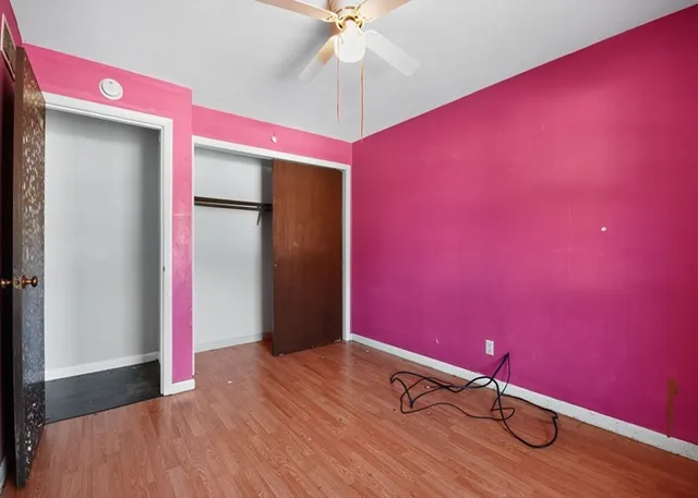 a room with wooden floor and fan