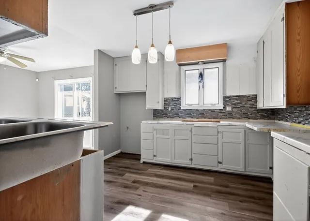 a kitchen with granite countertop a sink cabinets and window