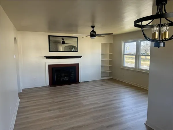 a view of an empty room with a window and fireplace