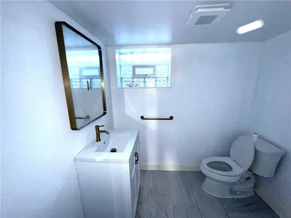 a bathroom with a toilet a sink and mirror