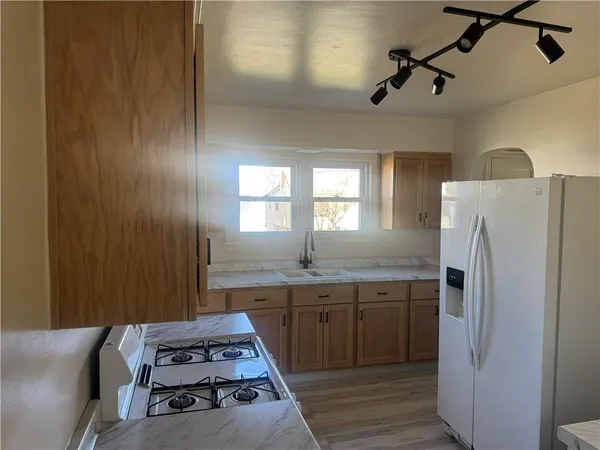 a kitchen with stainless steel appliances granite countertop a refrigerator and a sink