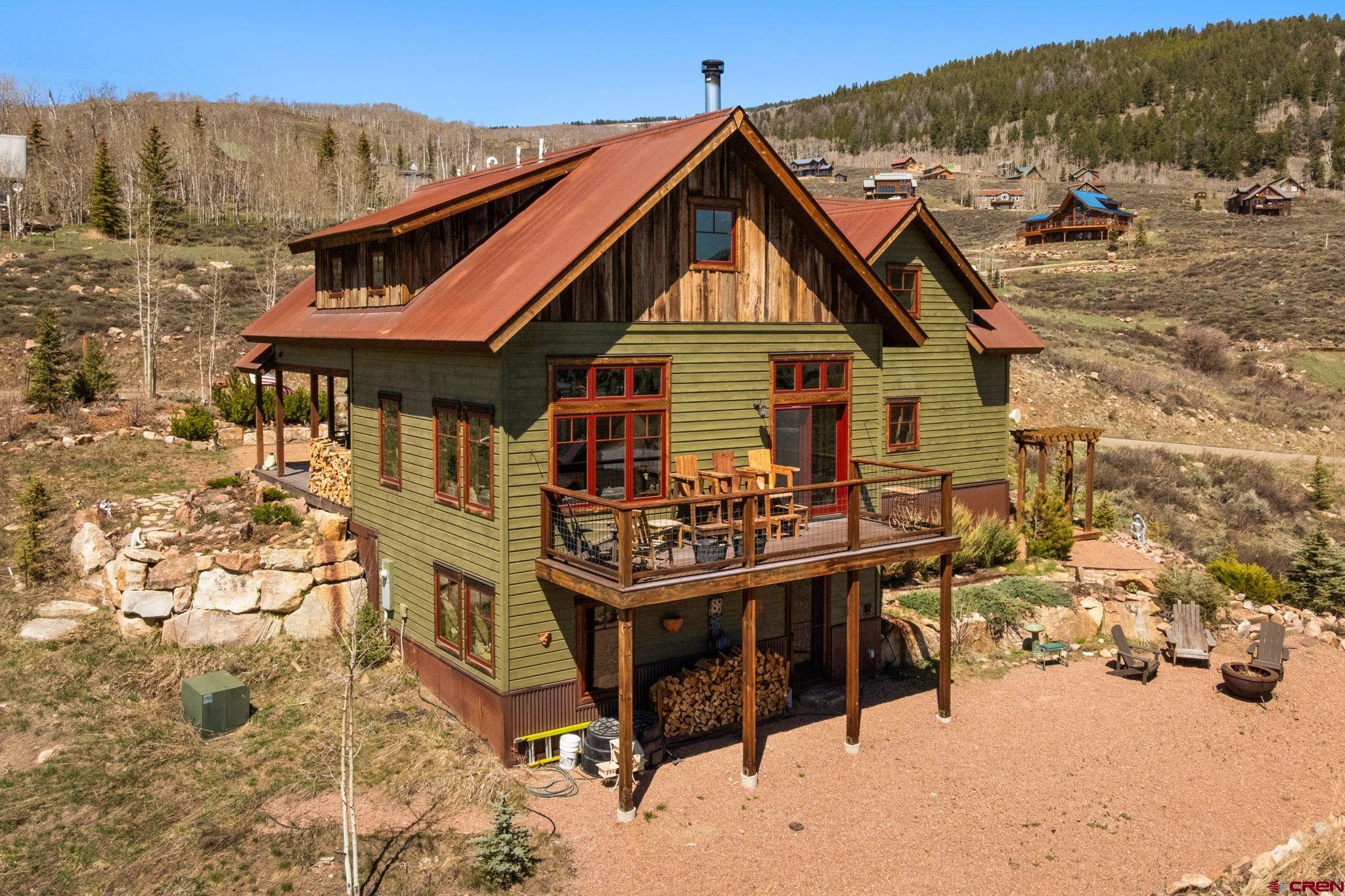 a view of a house with wooden deck and furniture