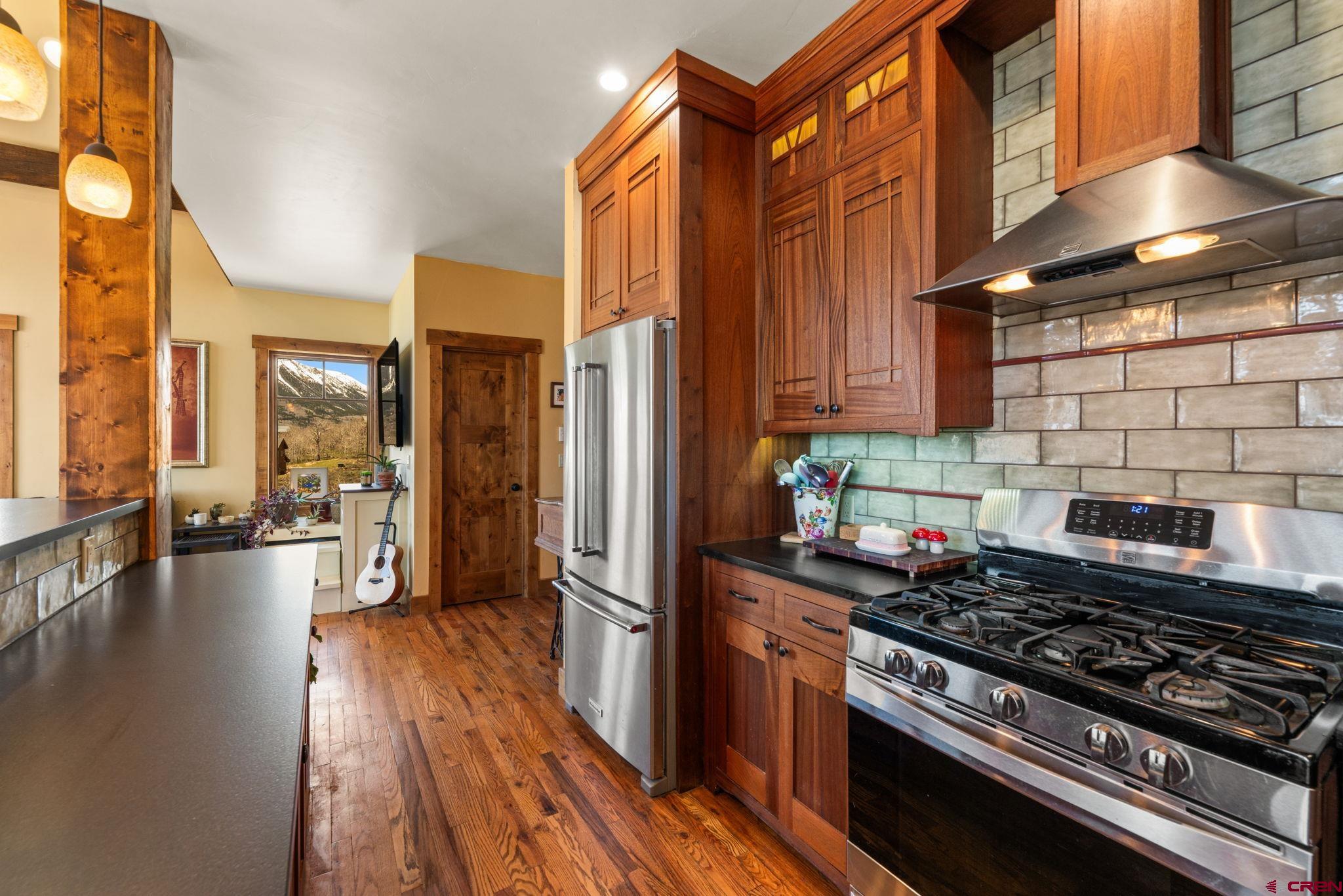 3893 Bryant Avenue Crested Butte, CO 81224 - Photo 11 of 45 a kitchen with stainless steel appliances granite countertop a stove and a wooden floors