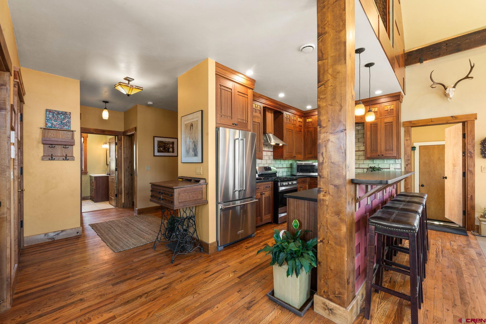 3893 Bryant Avenue Crested Butte, CO 81224 - Photo 6 of 45 a open kitchen with stainless steel appliances a refrigerator and wooden floor