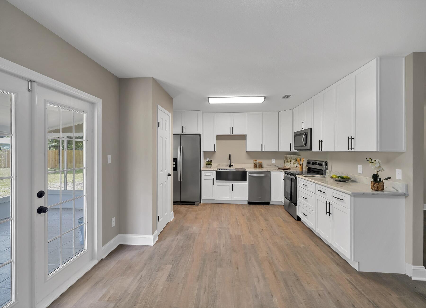 6935 Jasper Street Navarre, FL 32566 - Photo 1 of 45 a kitchen with white cabinets and white appliances