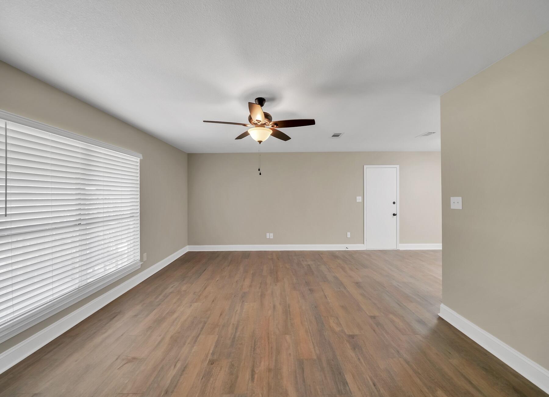 6935 Jasper Street Navarre, FL 32566 - Photo 12 of 45 wooden floor in an empty room with a window