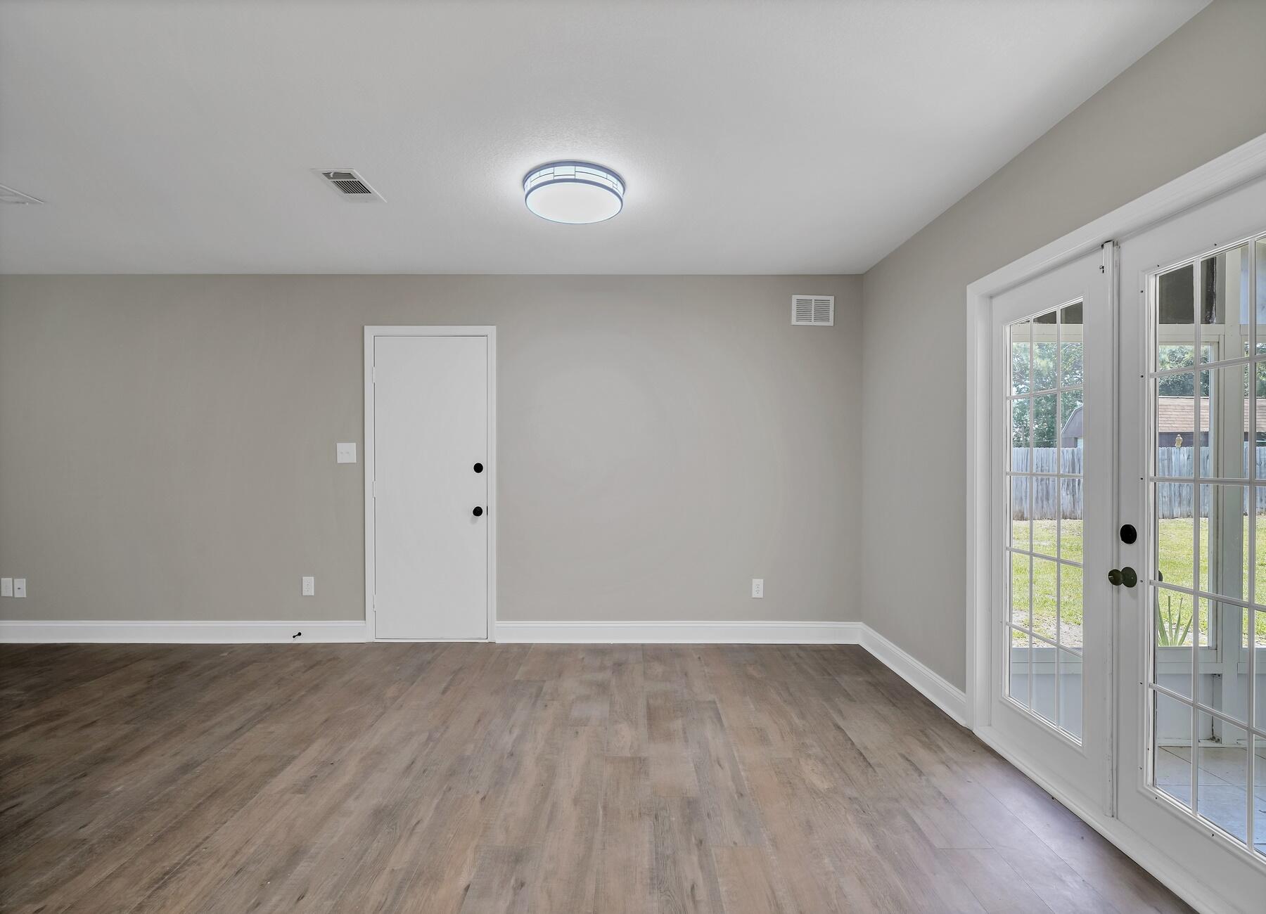 6935 Jasper Street Navarre, FL 32566 - Photo 13 of 45 wooden floor in an empty room with a window