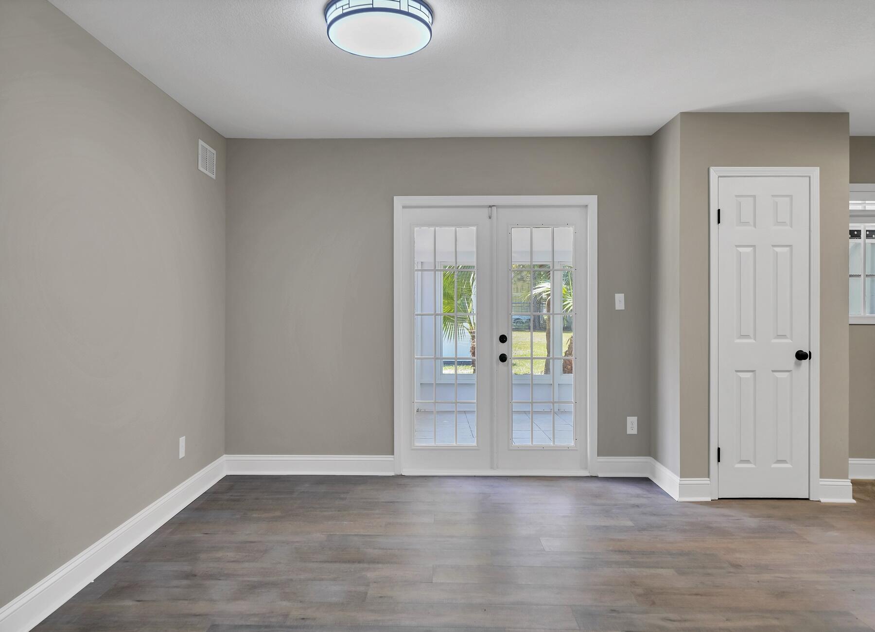 6935 Jasper Street Navarre, FL 32566 - Photo 14 of 45 an empty room with wooden floor and windows