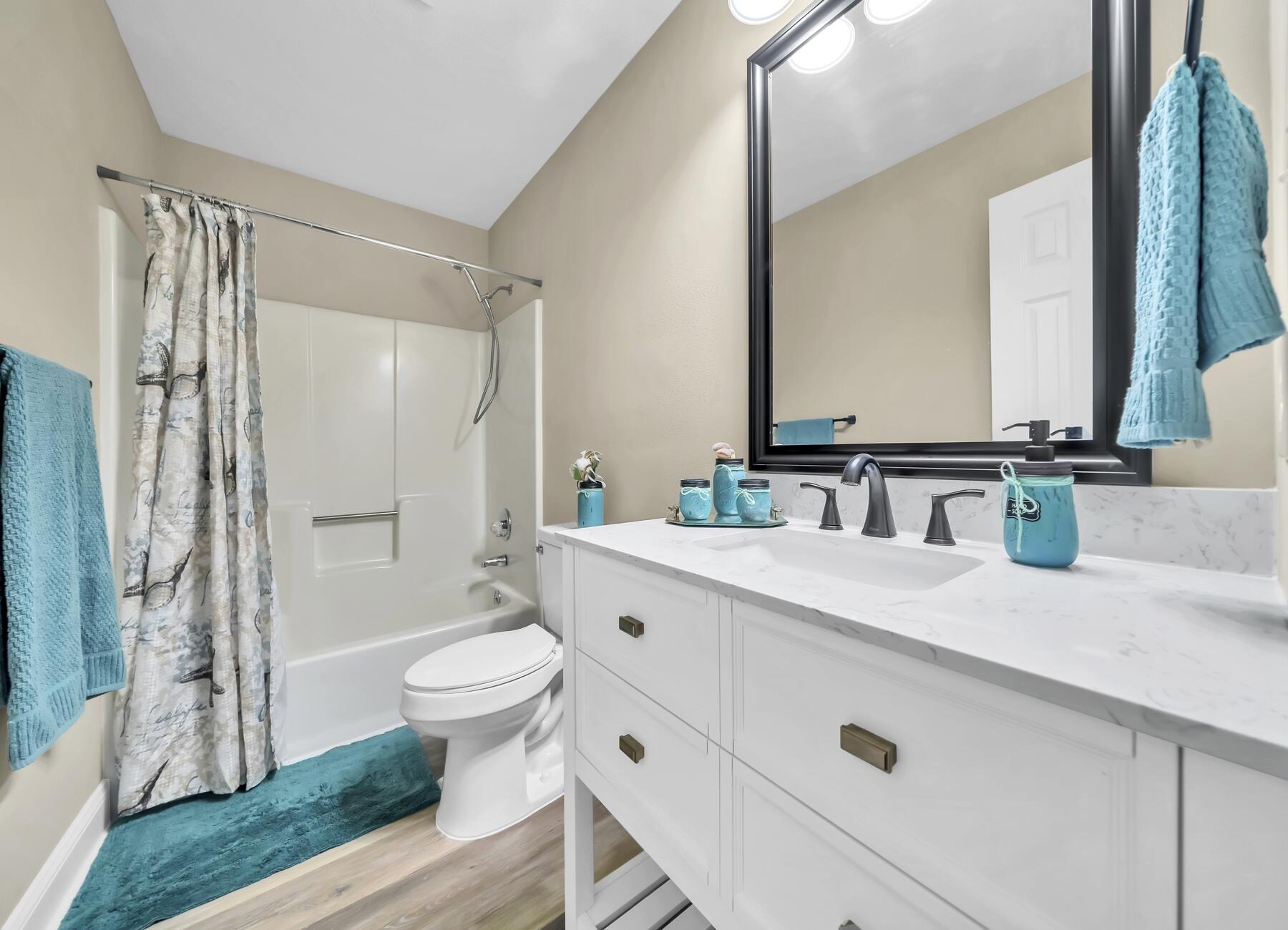 6935 Jasper Street Navarre, FL 32566 - Photo 17 of 45 a bathroom with a sink a toilet a mirror and shower