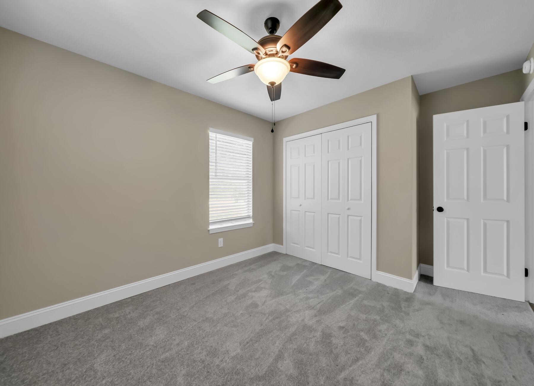 6935 Jasper Street Navarre, FL 32566 - Photo 27 of 45 an empty room with window and ceiling fan