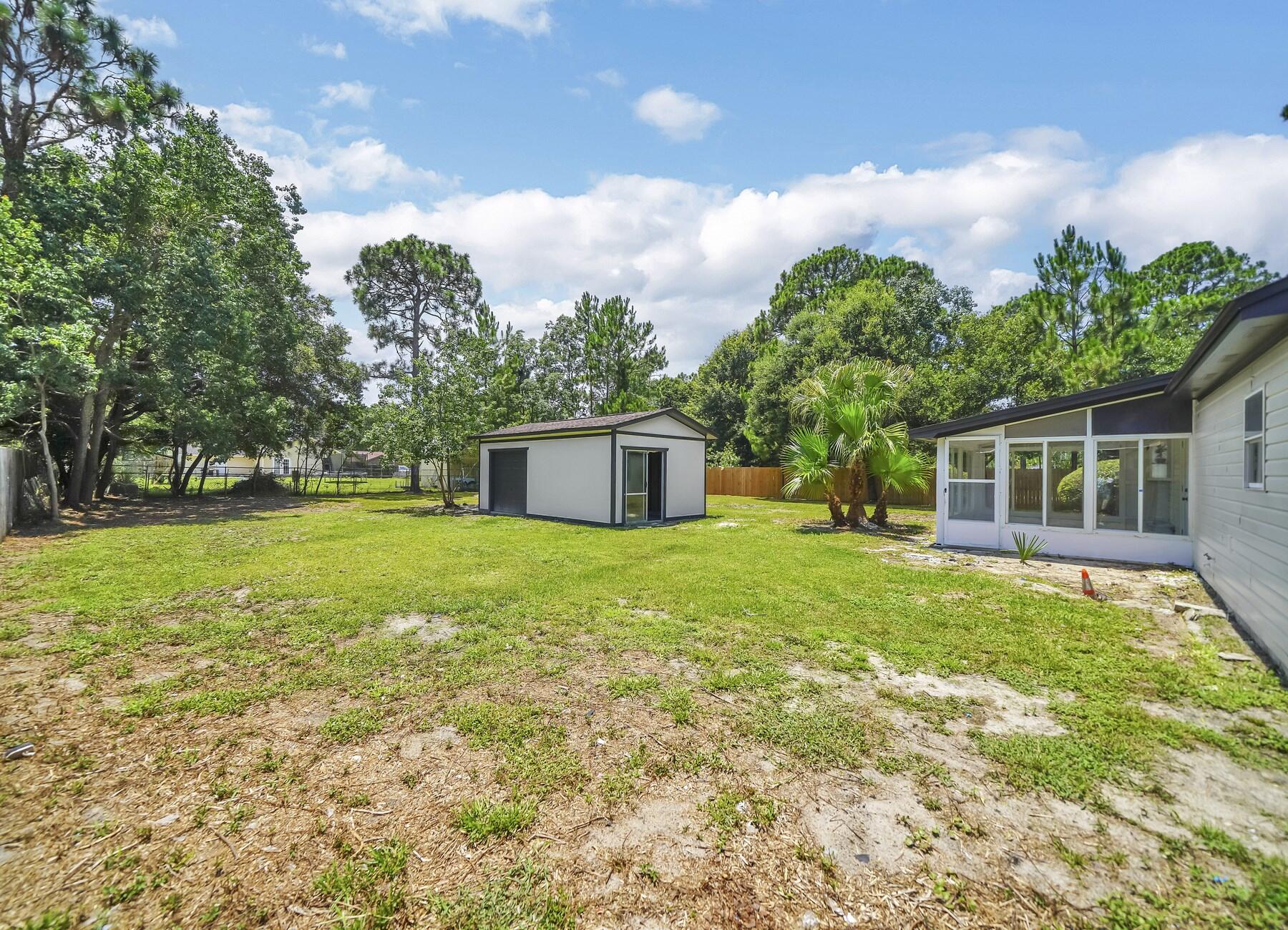 6935 Jasper Street Navarre, FL 32566 - Photo 38 of 45 a front view of house with yard and green space