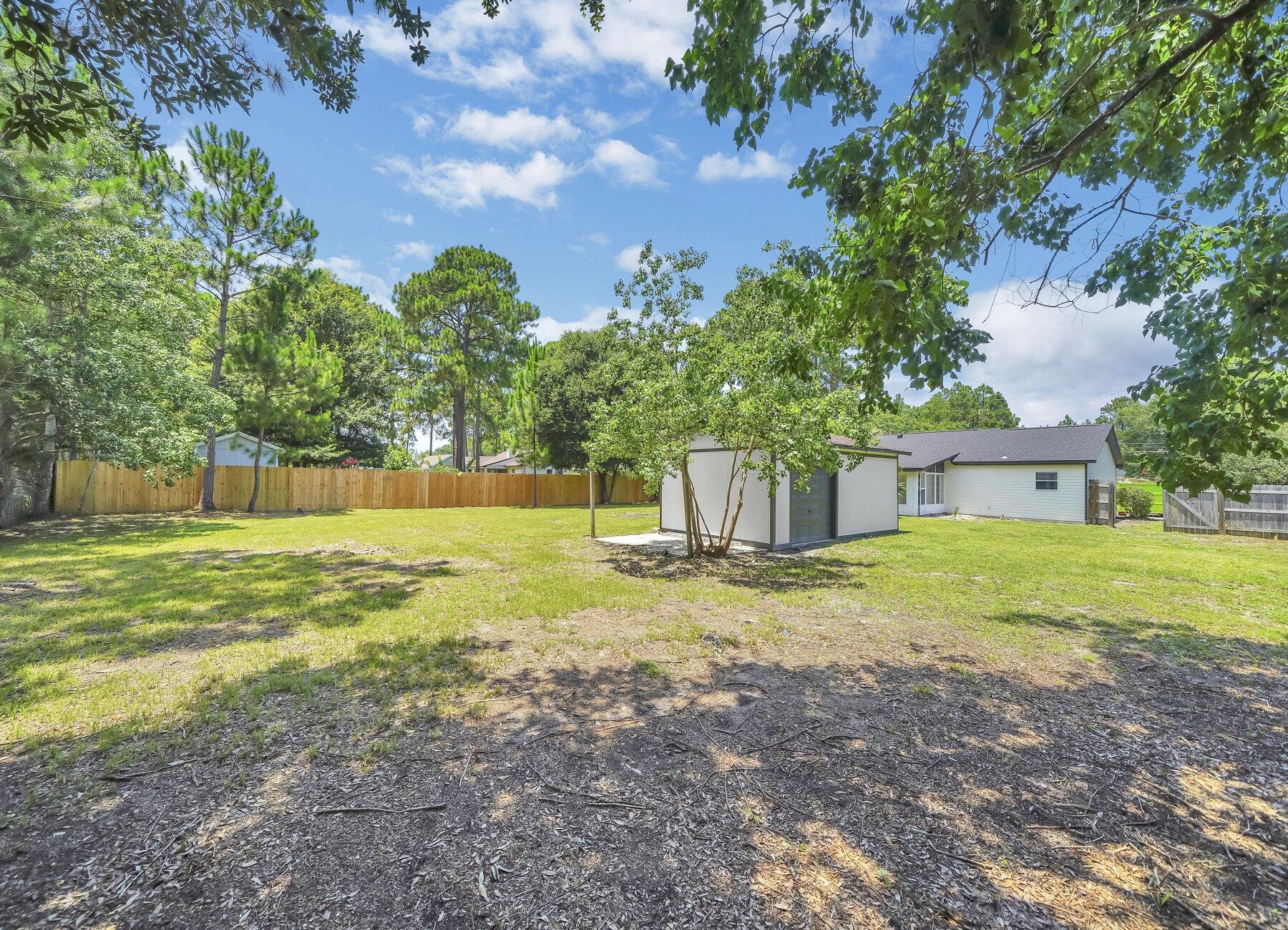 6935 Jasper Street Navarre, FL 32566 - Photo 39 of 45 a view of a yard with a house