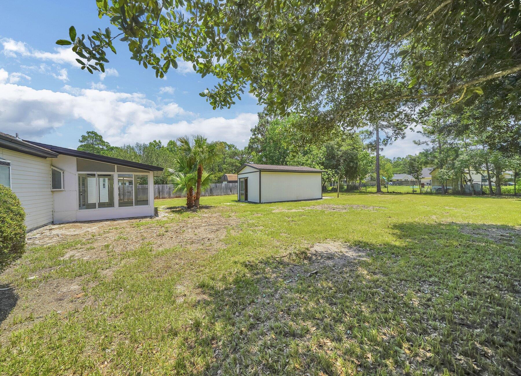 6935 Jasper Street Navarre, FL 32566 - Photo 42 of 45 a view of a house with backyard and a tree