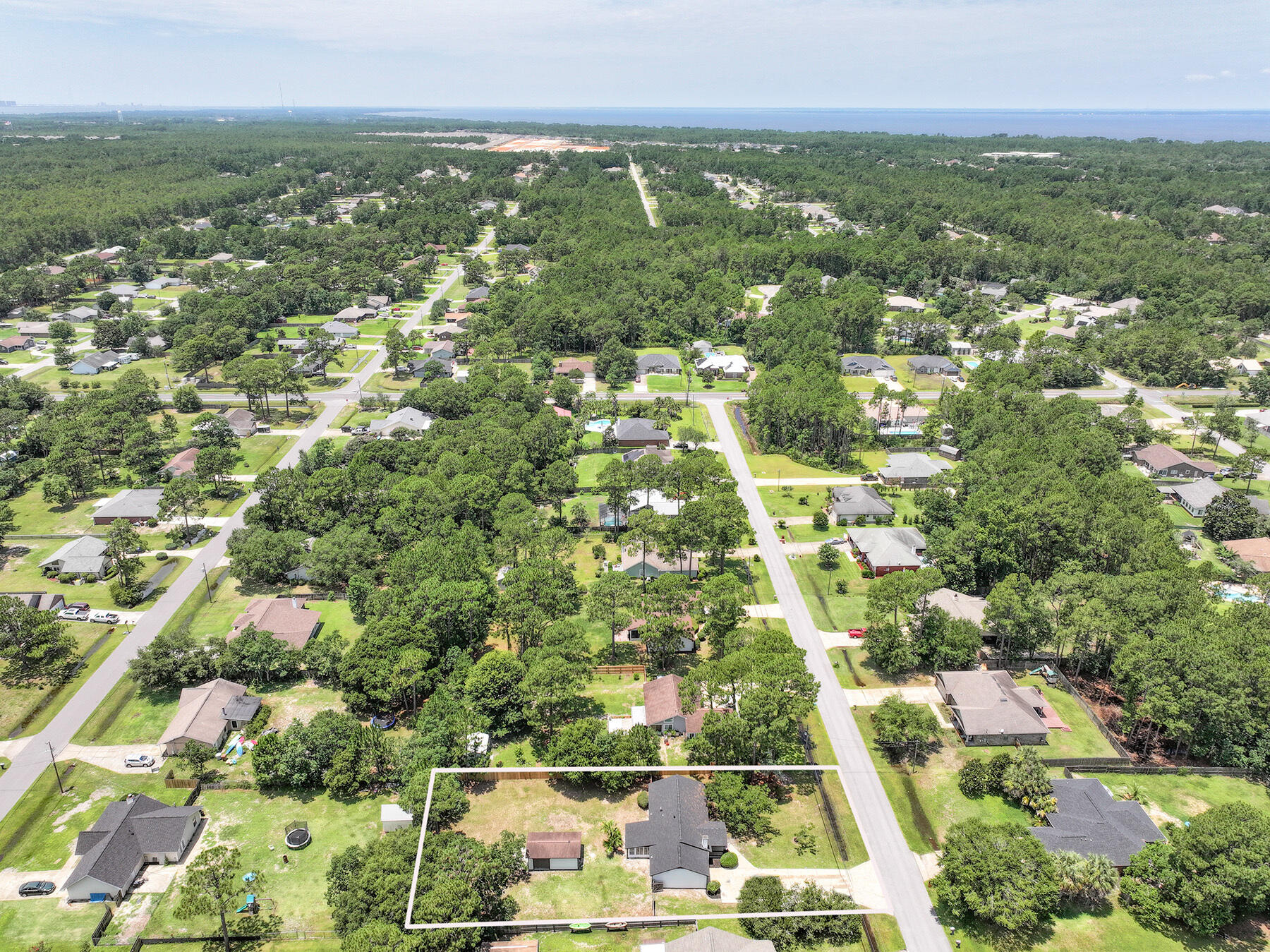 6935 Jasper Street Navarre, FL 32566 - Photo 44 of 45 an aerial view of residential houses with outdoor space and trees