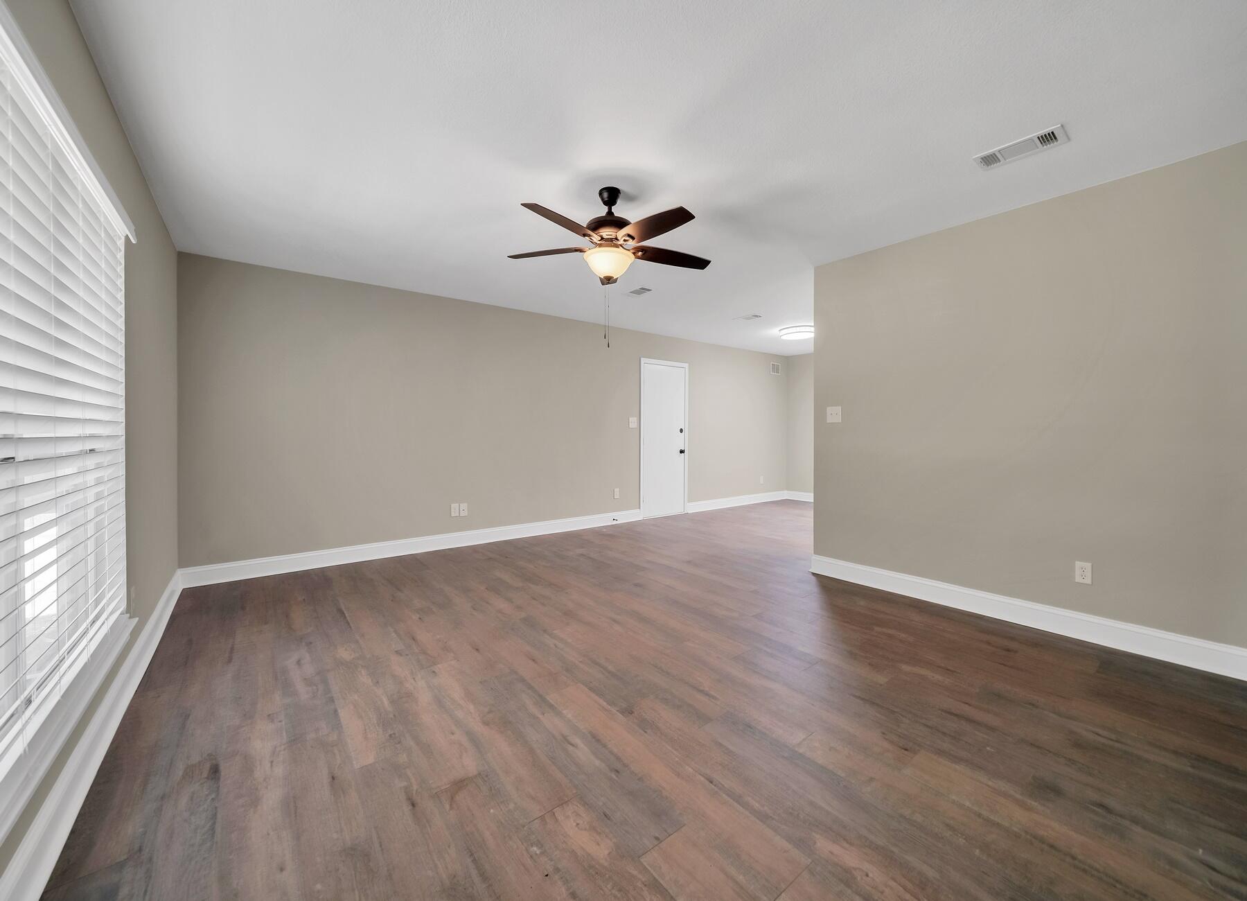 6935 Jasper Street Navarre, FL 32566 - Photo 8 of 45 a view of a room with wooden floor and a ceiling fan