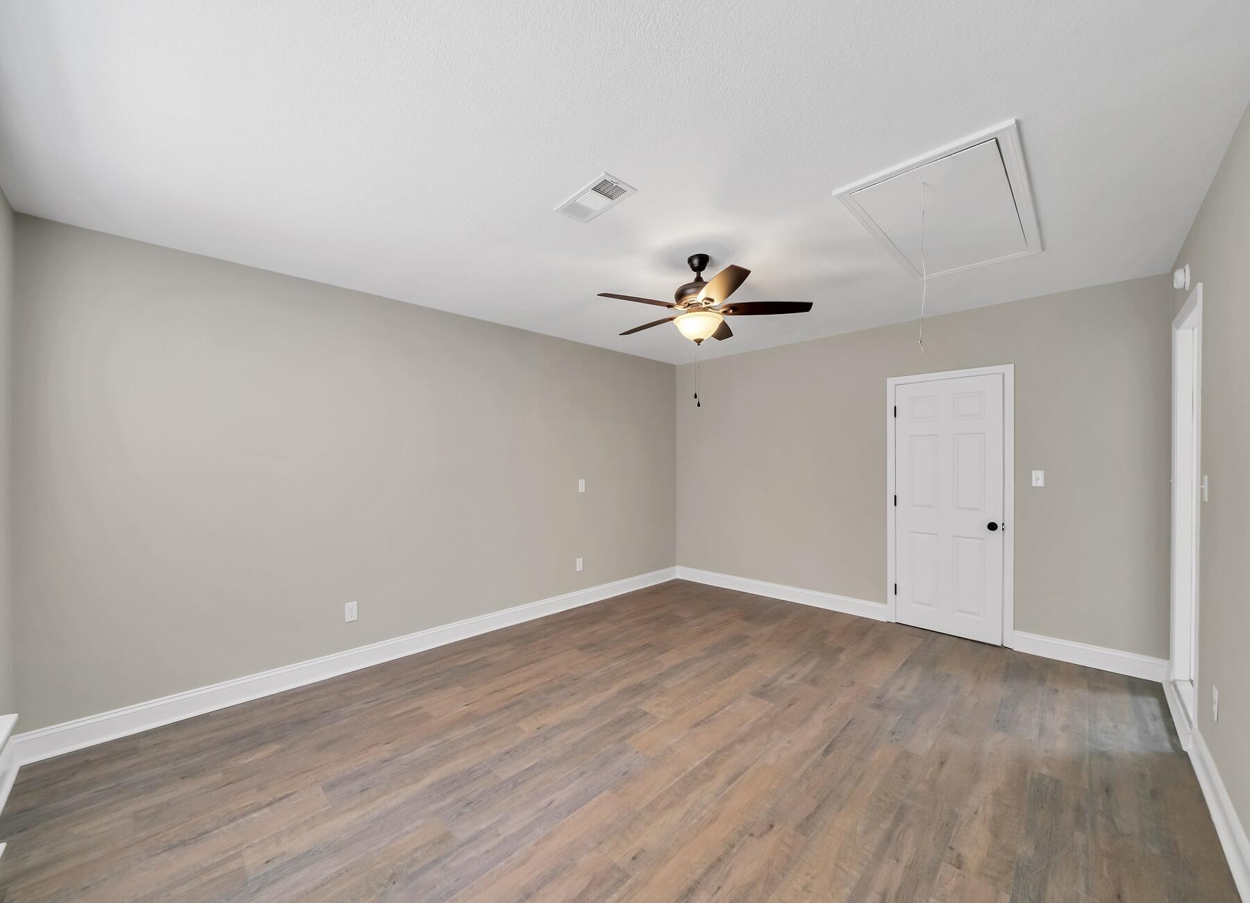 6935 Jasper Street Navarre, FL 32566 - Photo 9 of 45 a view of an empty room with wooden floor