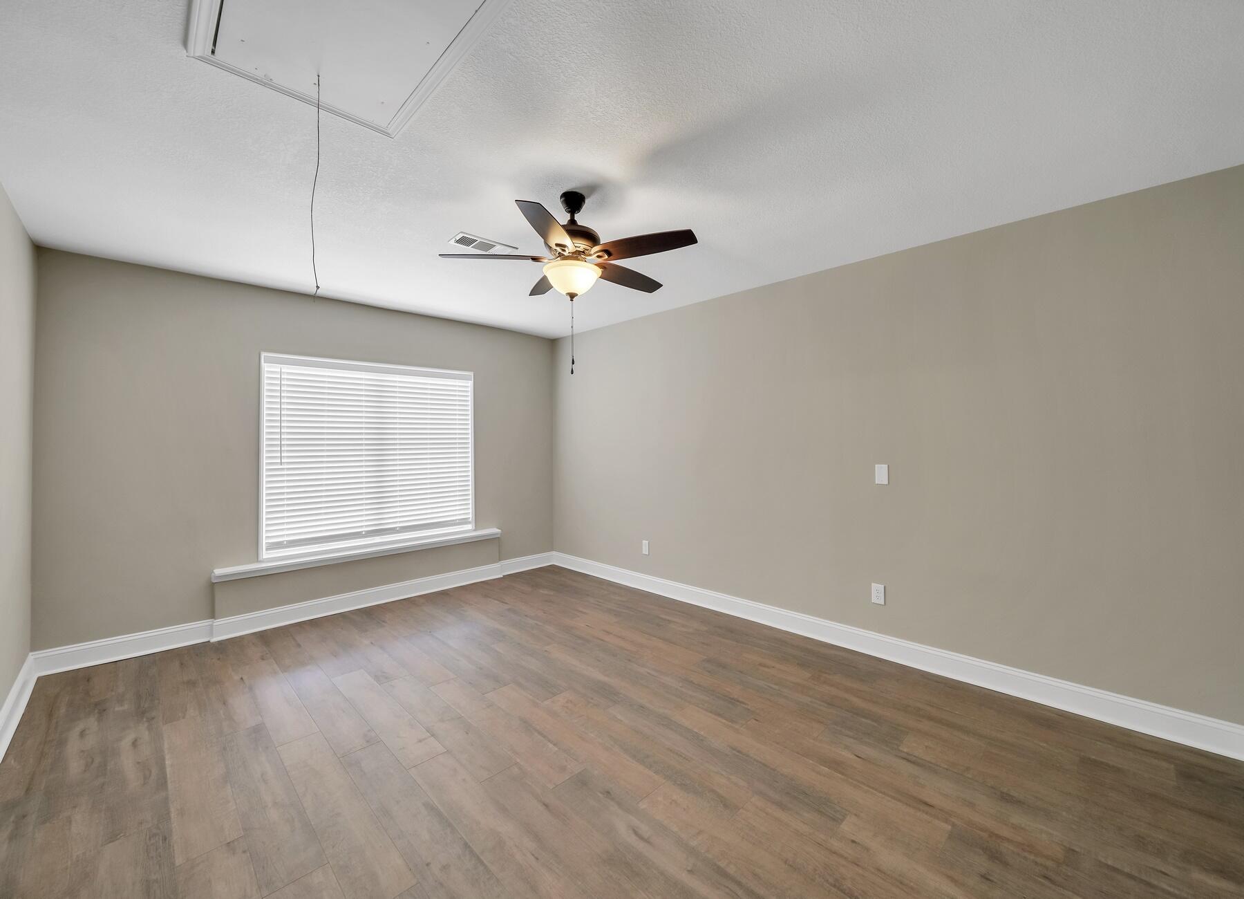 6935 Jasper Street Navarre, FL 32566 - Photo 10 of 45 wooden floor in an empty room with a window