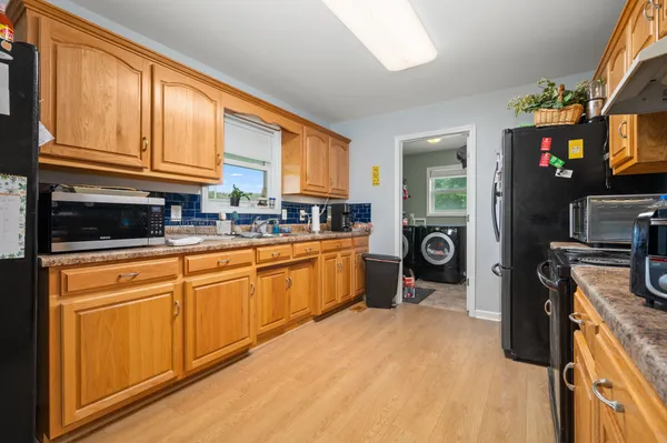 a kitchen with stainless steel appliances granite countertop a stove a sink and a refrigerator