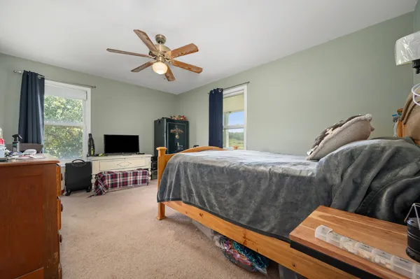 a bedroom with a bed a couch and a window