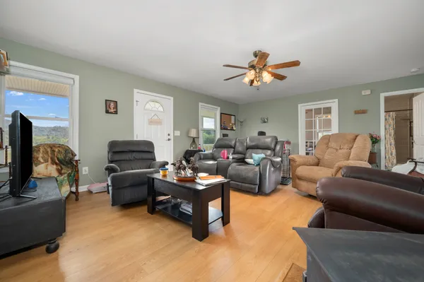 a living room with furniture a ceiling fan and a window