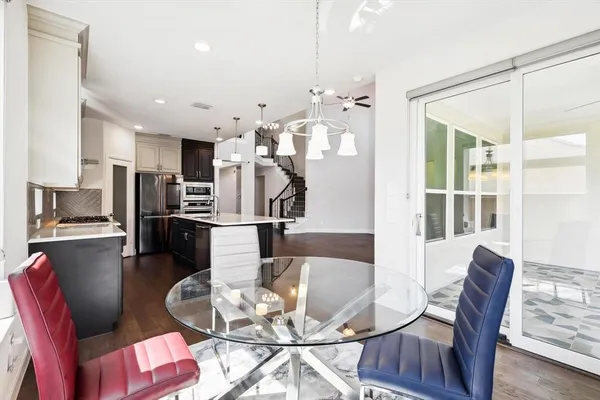 a view of a dining room with furniture a kitchen and chandelier