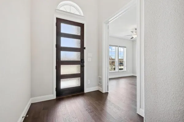an empty room with wooden floor cabinet and window