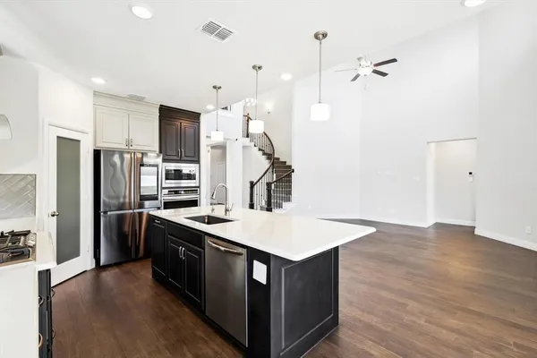 a kitchen with stainless steel appliances granite countertop a sink a stove and a refrigerator
