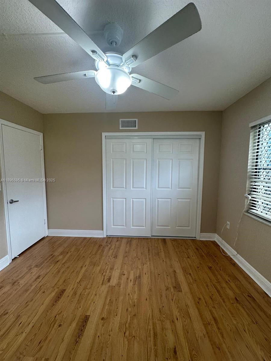 9848 Marina Boulevard, Unit 811 Boca Raton, FL 33428 - Photo 39 of 87 a view of an empty room with wooden floor and a window