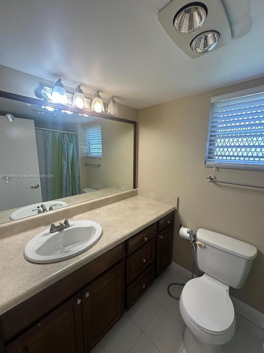 9848 Marina Boulevard, Unit 811 Boca Raton, FL 33428 - Photo 62 of 87 a bathroom with a toilet a sink and mirror