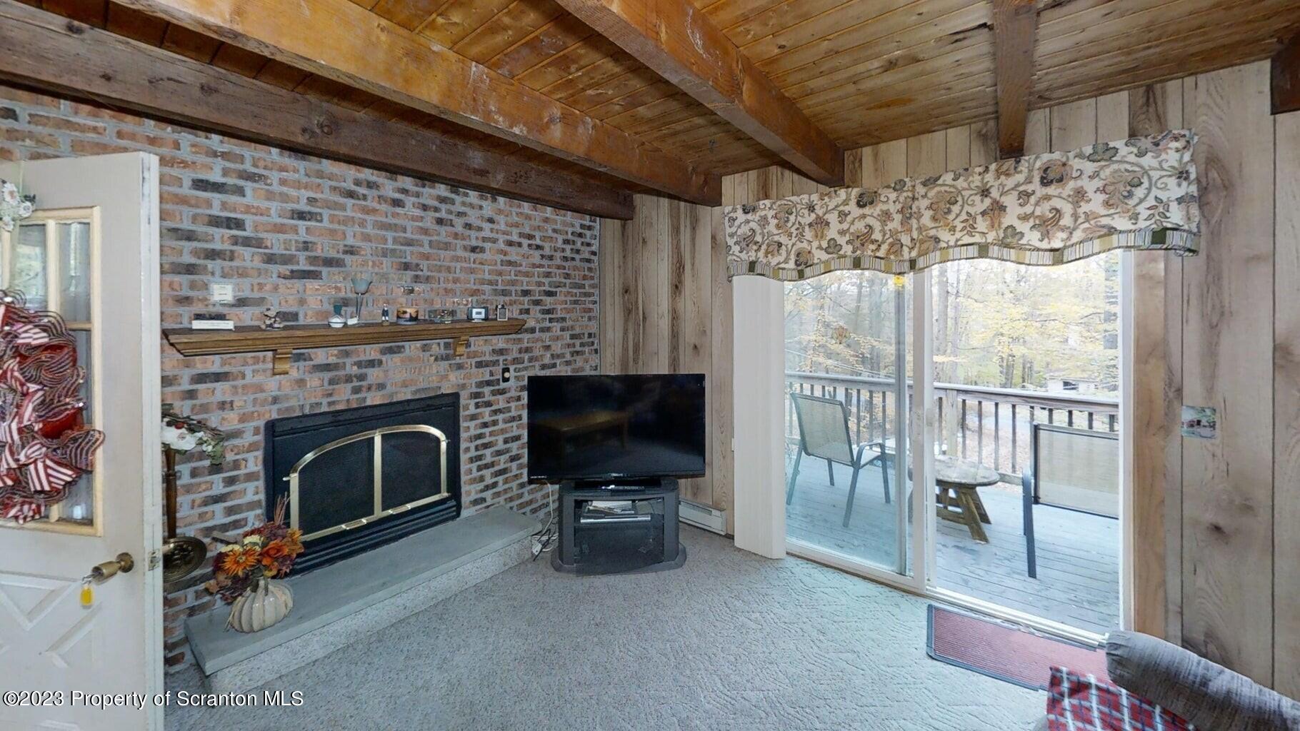 1144 Commanche Circle Lake Ariel, PA 18436 - Photo 19 of 28 a living room with furniture a fireplace and a flat screen tv