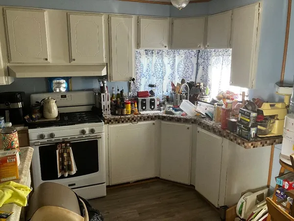 a kitchen with stainless steel appliances granite countertop a stove a sink and a white cabinets