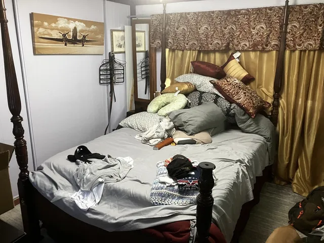 a bed sitting in a bedroom next to a window