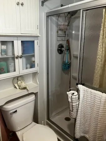a bathroom with a granite countertop sink toilet and shower