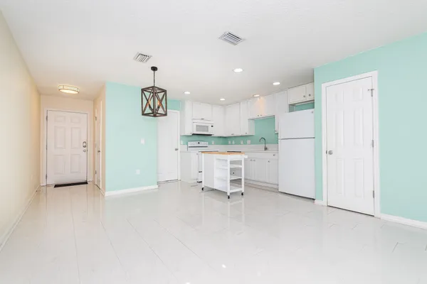 a kitchen with stainless steel appliances kitchen island granite countertop a refrigerator and a sink