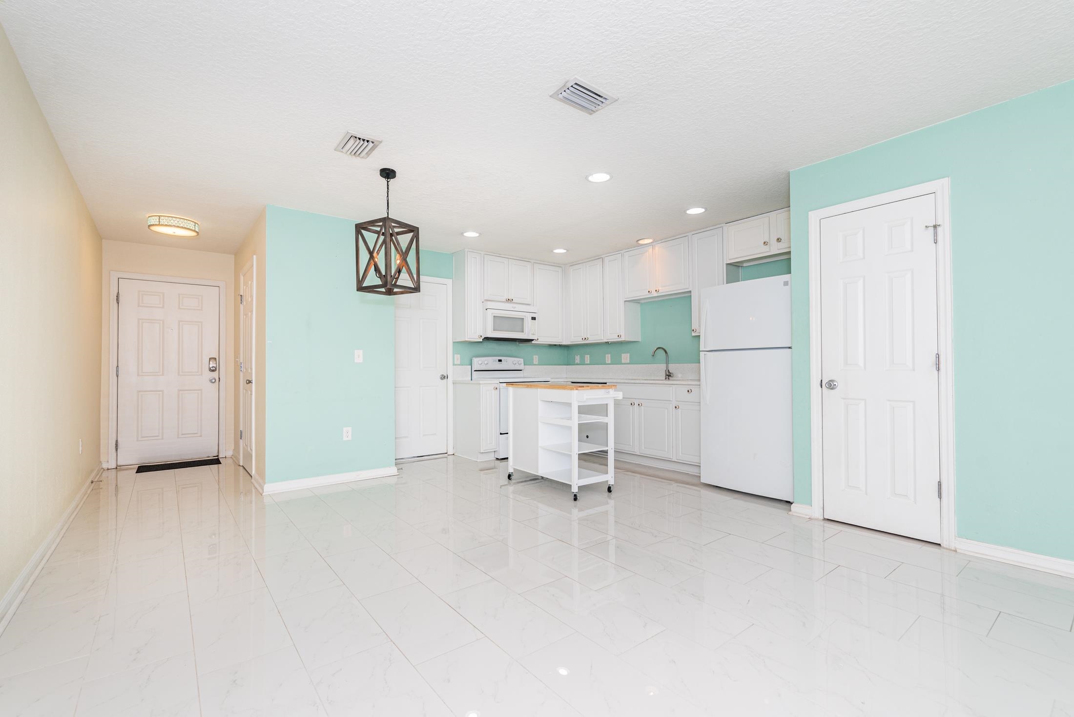 128 A Islander Circle St. Augustine, FL 32080 - Photo 4 of 26 a kitchen with stainless steel appliances kitchen island granite countertop a refrigerator and a sink