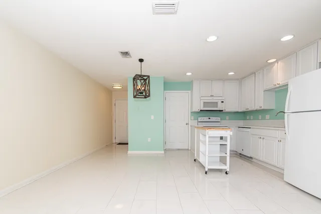 a open kitchen with stainless steel appliances granite countertop a refrigerator and a stove top oven