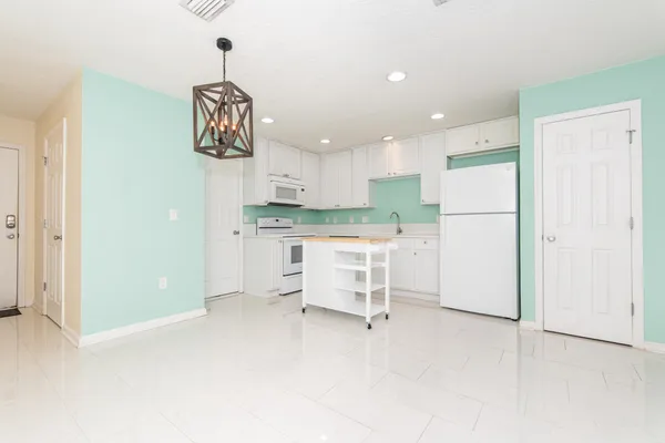 a kitchen with a refrigerator and white cabinets