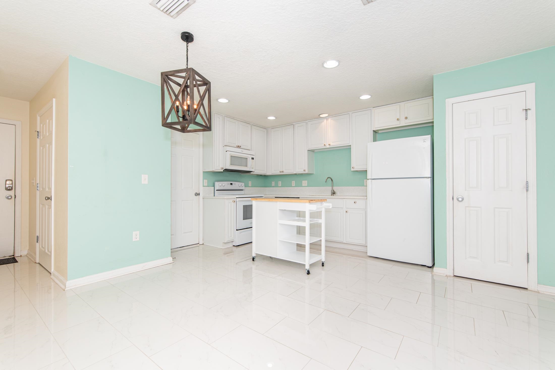 128 A Islander Circle St. Augustine, FL 32080 - Photo 7 of 26 a kitchen with a refrigerator and white cabinets