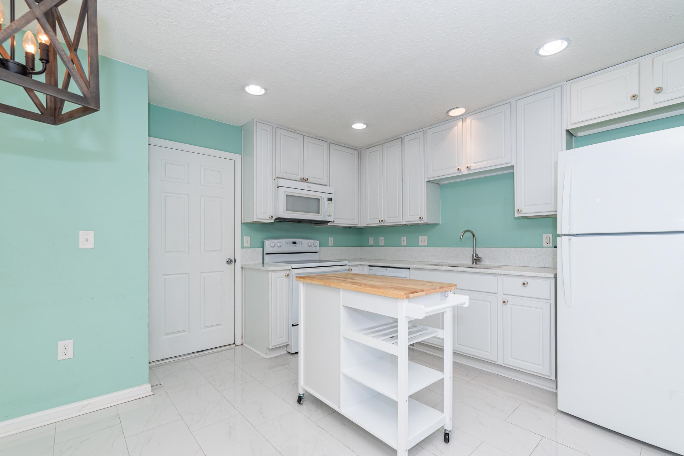 128 A Islander Circle St. Augustine, FL 32080 - Photo 8 of 26 a kitchen with a sink a stove a refrigerator and white cabinets